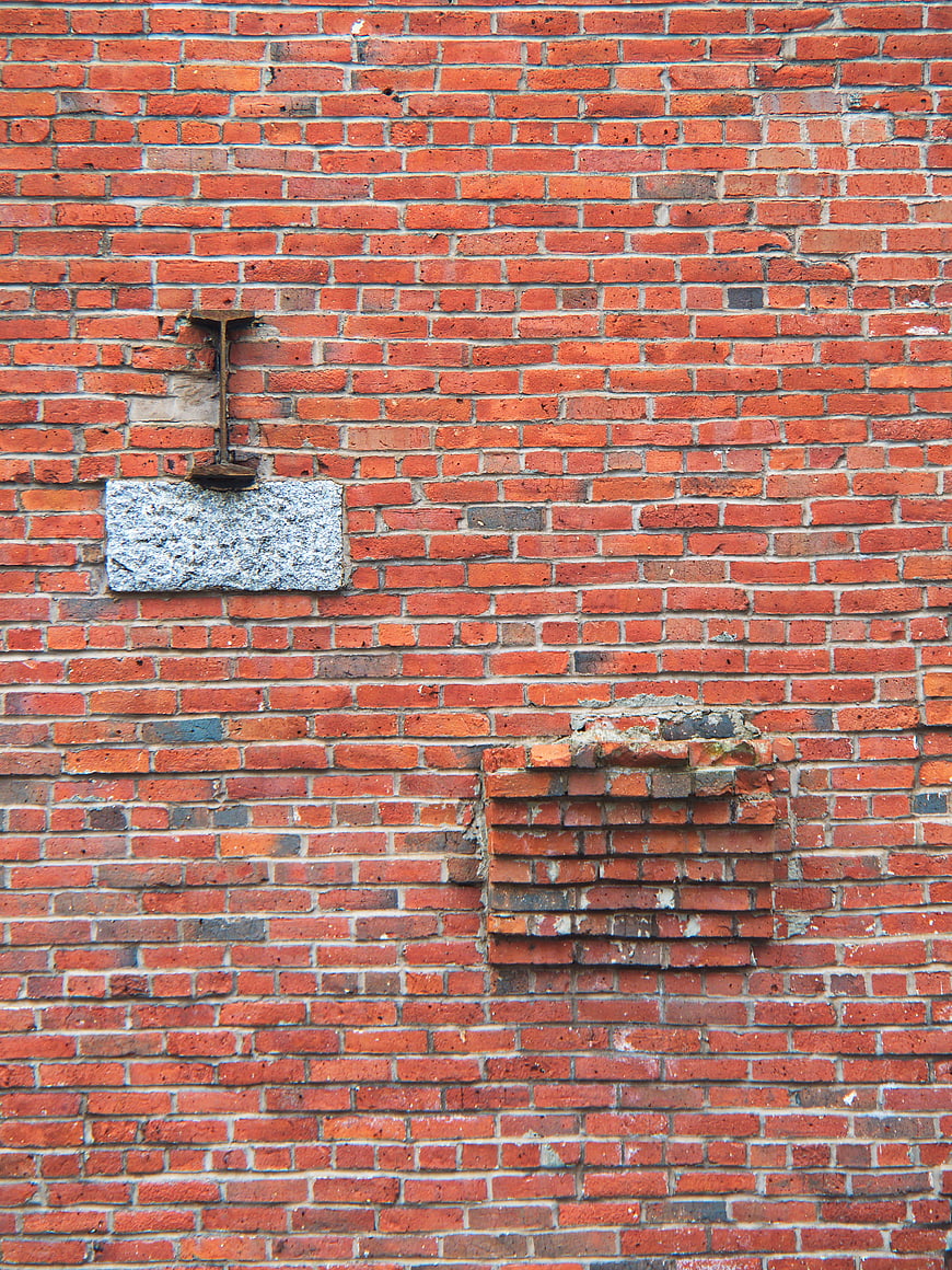 Weathered Red Brick Wall with Stone and Metal Details