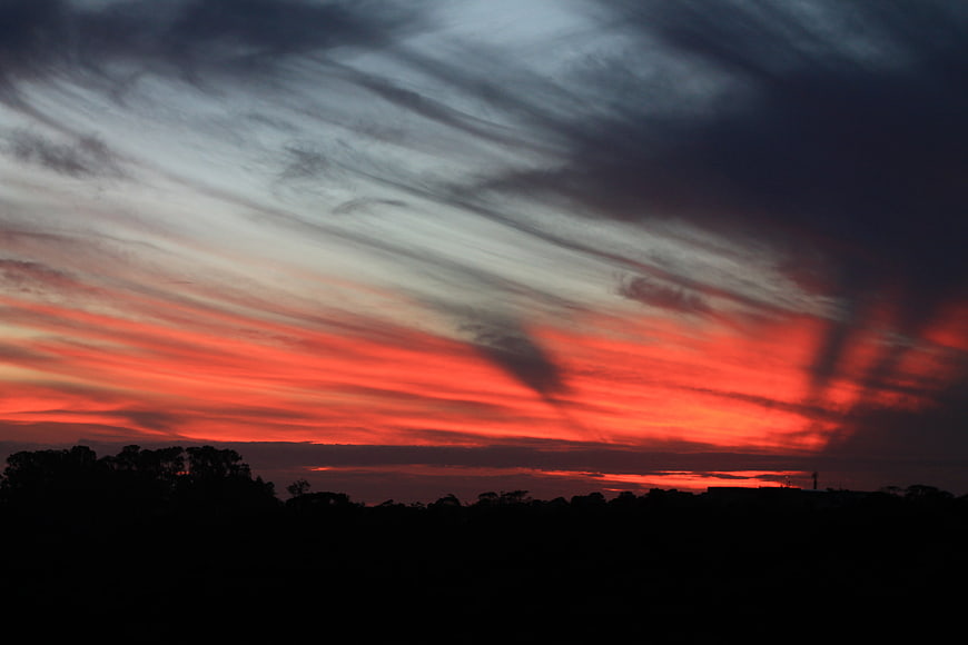 Dramatic Red Sunset Sky With Dark Silhouette Landscape