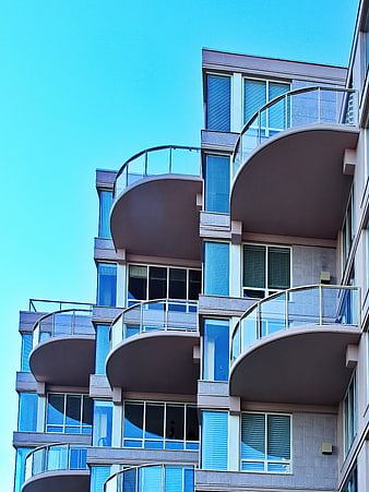 Modern Apartment Building with Curved Balconies and Blue Sky