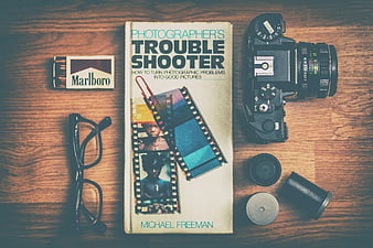 Vintage photography flat lay with camera, book, and film