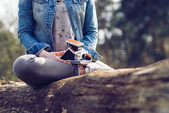 Woman Sitting on Log with Vintage Polaroid Camera