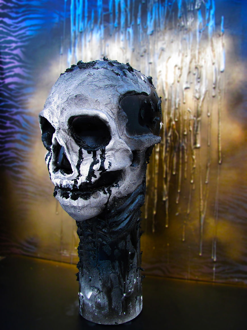 Handmade silver skull sculpture with black dripping paint