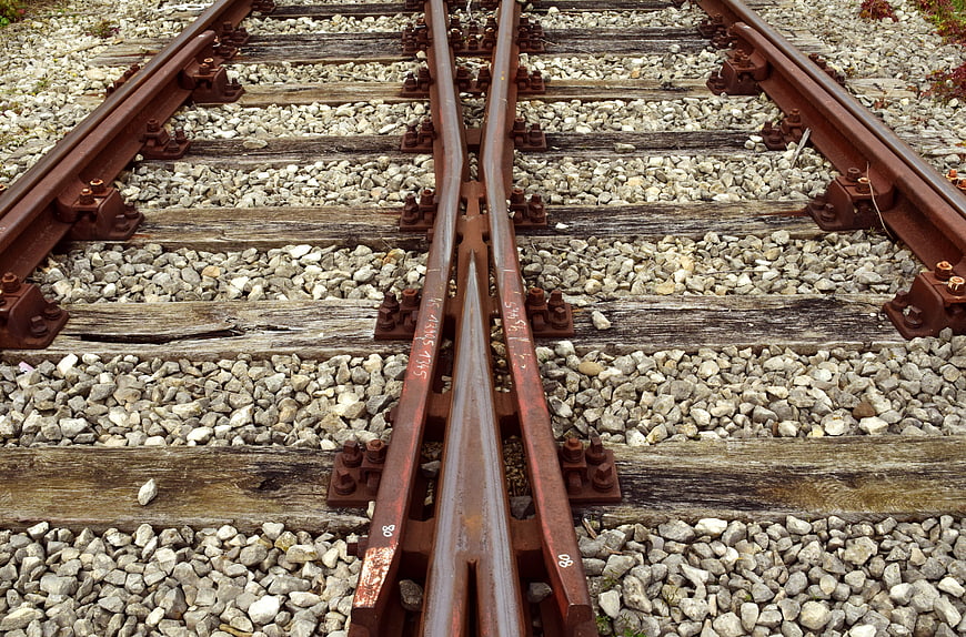 Close-up of rusty railroad track junction on gravel ballast