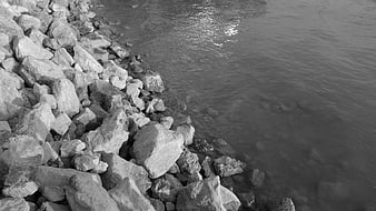 Black and white rocky shoreline with calm water