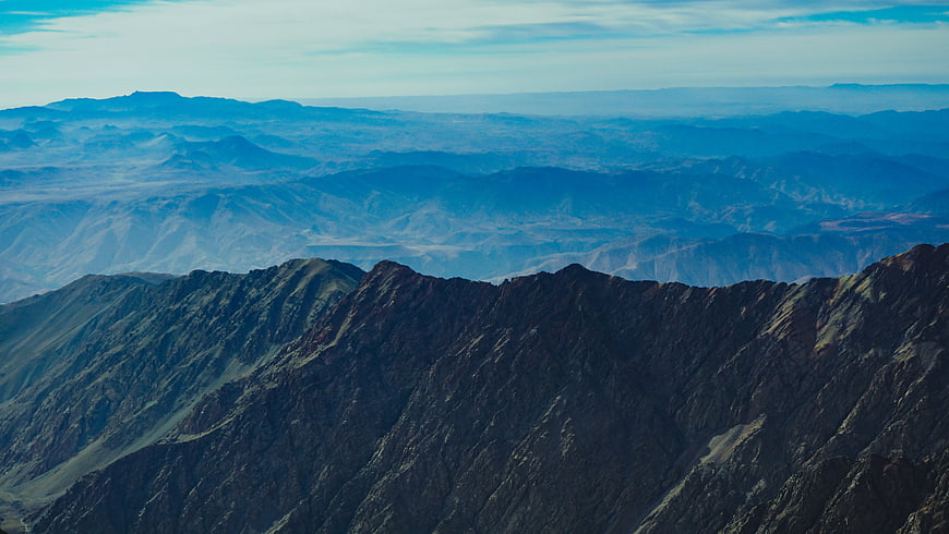 Panoramic View of Layered Mountain Ranges with Blue Haze