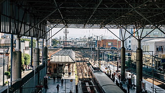 Urban train station platform with commuters and tracks