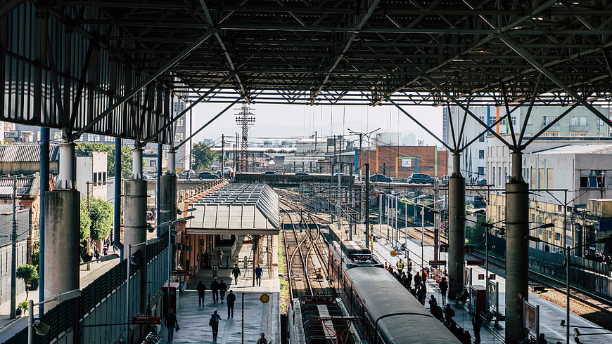 Urban train station platform with commuters and tracks