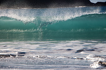 Powerful turquoise ocean wave crashing with white foam