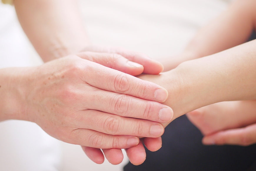 Close-up of elderly hand holding younger hand
