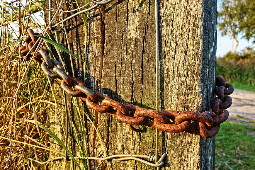 Rusty Chain Wrapped Around Weathered Wooden Post