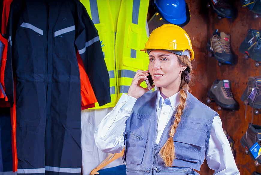 Female construction worker talking on phone in safety gear store