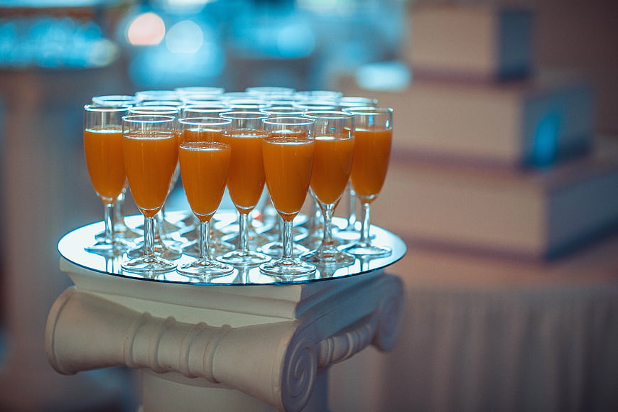 Orange Bellini Cocktails in Flute Glasses on a Pedestal