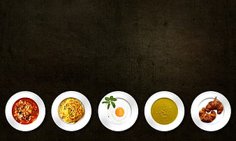Top View of Five White Plates with Various Dishes on Dark Background