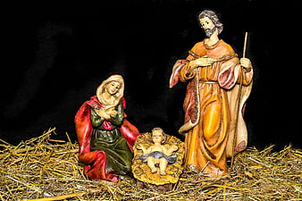 Nativity scene figures of Mary, Joseph, and baby Jesus on hay