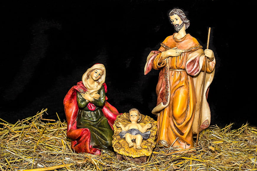 Nativity scene figures of Mary, Joseph, and baby Jesus on hay