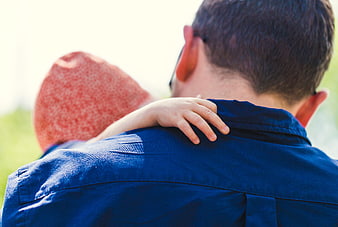 Father carrying child on shoulders outdoors