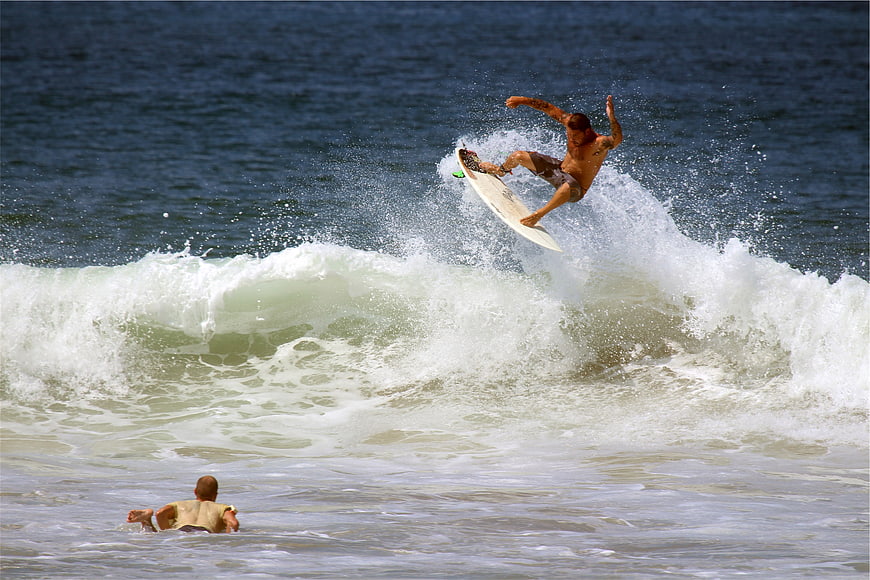 Surfer performing aerial maneuver on ocean wave
