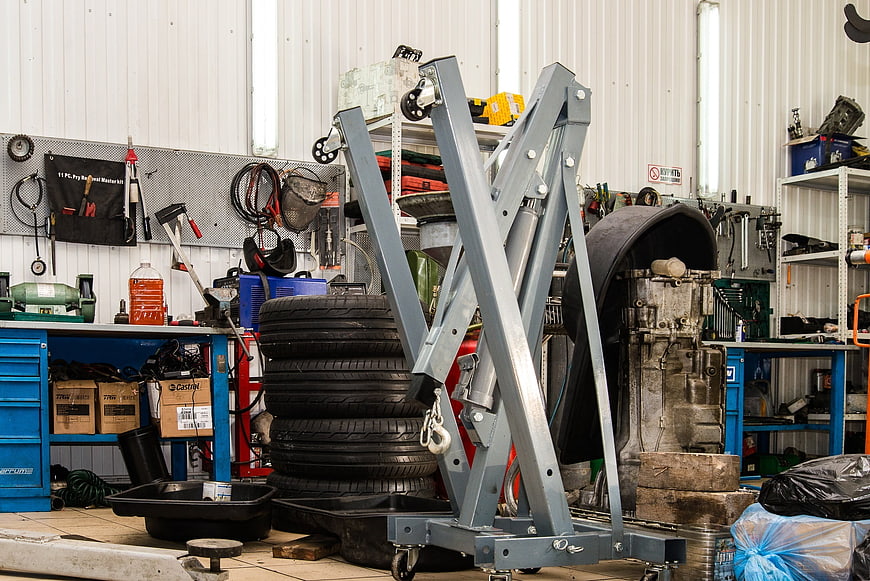 Auto Repair Shop Interior With Engine Hoist And Tires