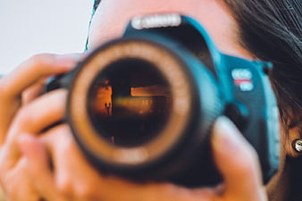 Close-up of Woman Holding DSLR Camera to Eye