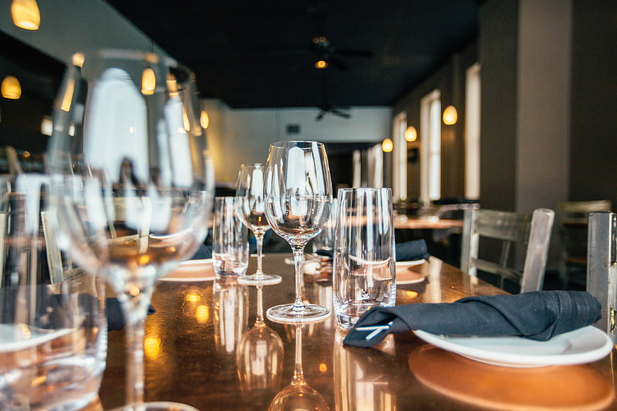 Elegant restaurant table setting with wine glasses and napkins