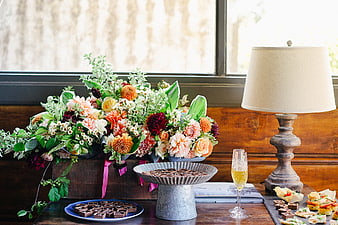Rustic floral centerpiece with desserts and champagne on wooden table
