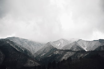 Snow-Covered Mountain Range Under Overcast Sky