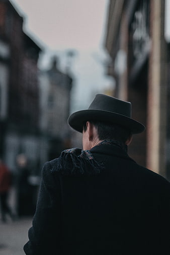 Man in Fedora Hat Walking Down City Street