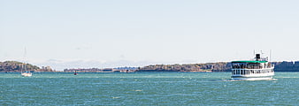 White Ferry Boat Crossing Blue Water with Distant Shoreline