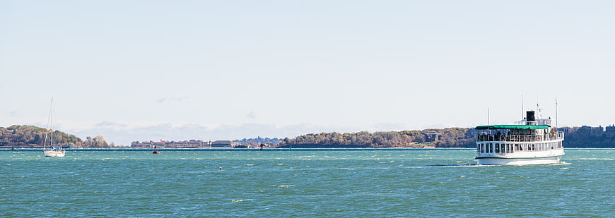 White Ferry Boat Crossing Blue Water with Distant Shoreline