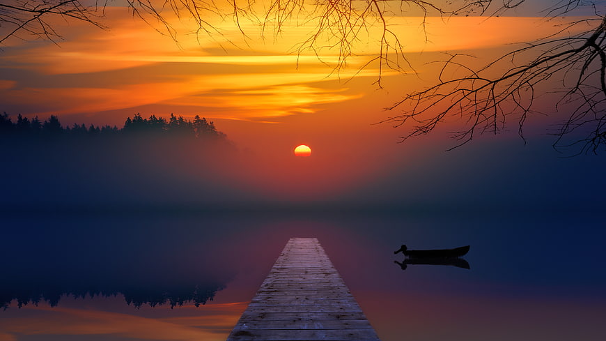 Serene Lake Sunset with Wooden Pier and Silhouetted Boat