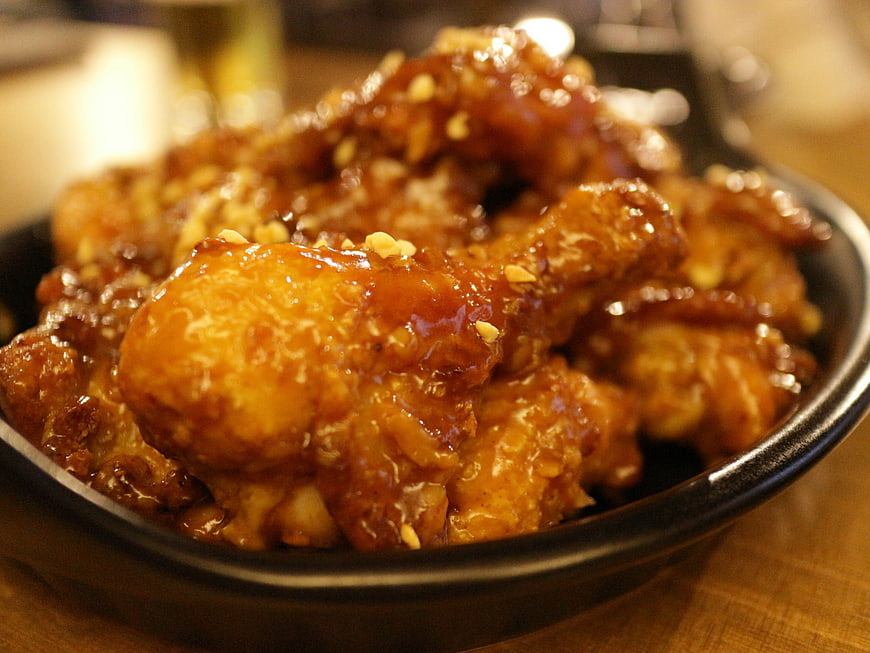 Glossy Honey Garlic Chicken Wings In Black Ceramic Bowl