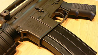 Close-up of black M4A1 carbine rifle on wooden surface