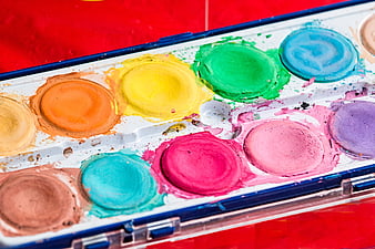 Close-up of colorful watercolor paint palette on red background