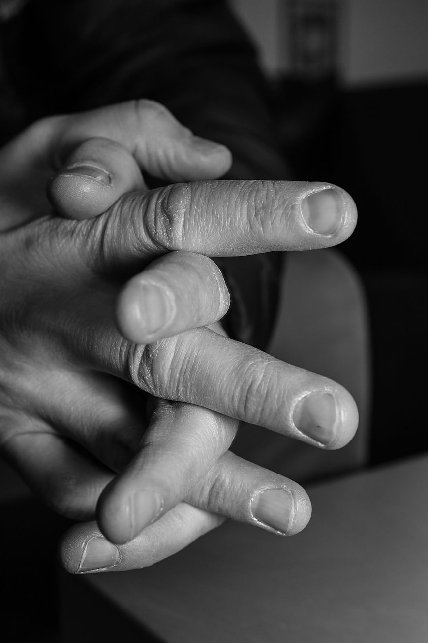Close-up of interlaced fingers in black and white
