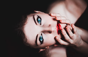Close-up portrait of woman with blue eyes and red lipstick