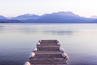 Serene Wooden Dock Extending into Calm Lake with Mountains