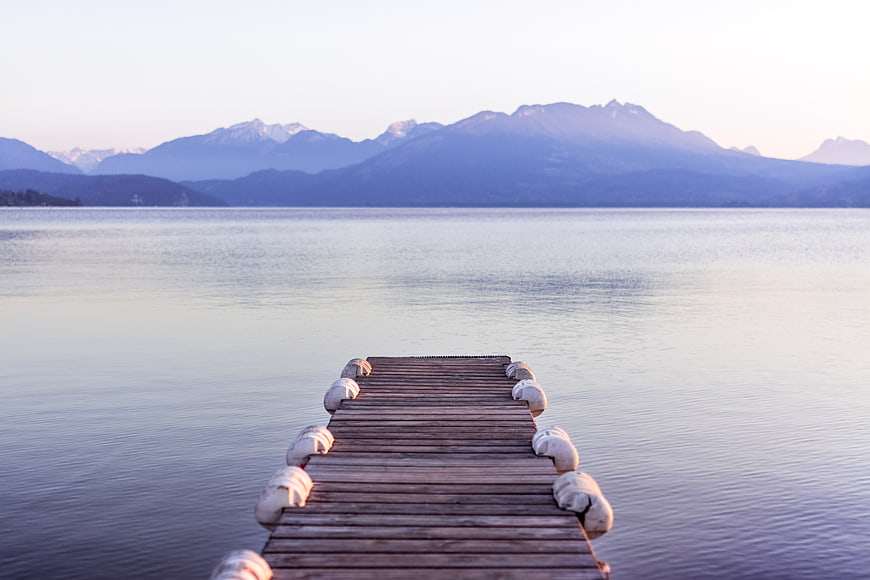Serene Wooden Dock Extending into Calm Lake with Mountains