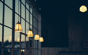 Warm pendant lights hanging in a dimly lit cafe interior