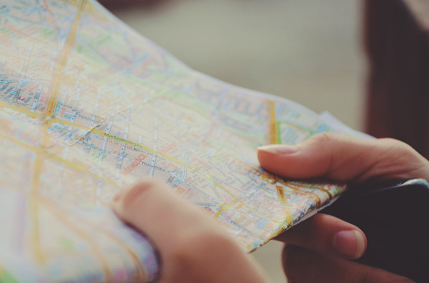 Close-up of hands holding a folded paper city map