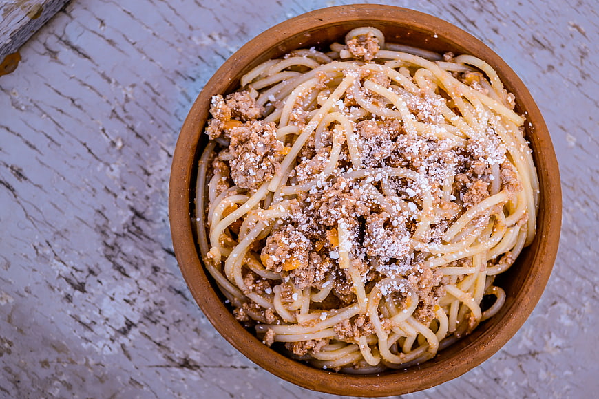 Top View of Spaghetti Bolognese in Rustic Clay Bowl
