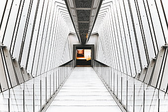 Modern white architectural corridor with glass railings and geometric lines
