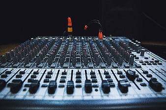 Close-up of professional audio mixing console with sliders and knobs