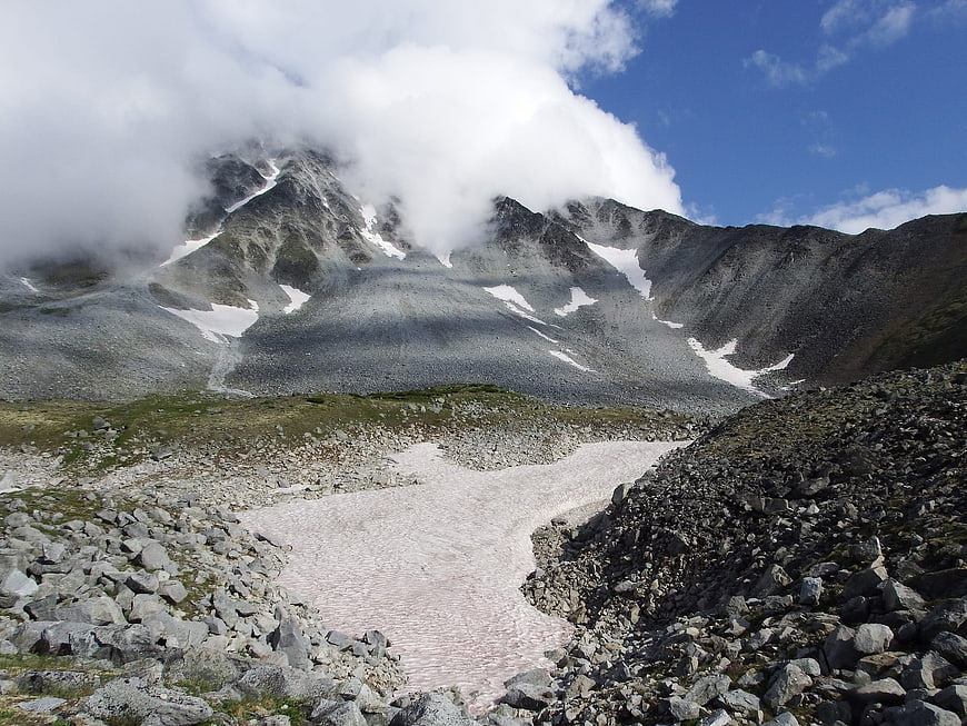 Rugged Mountain Landscape with Snow Patches and Clouds