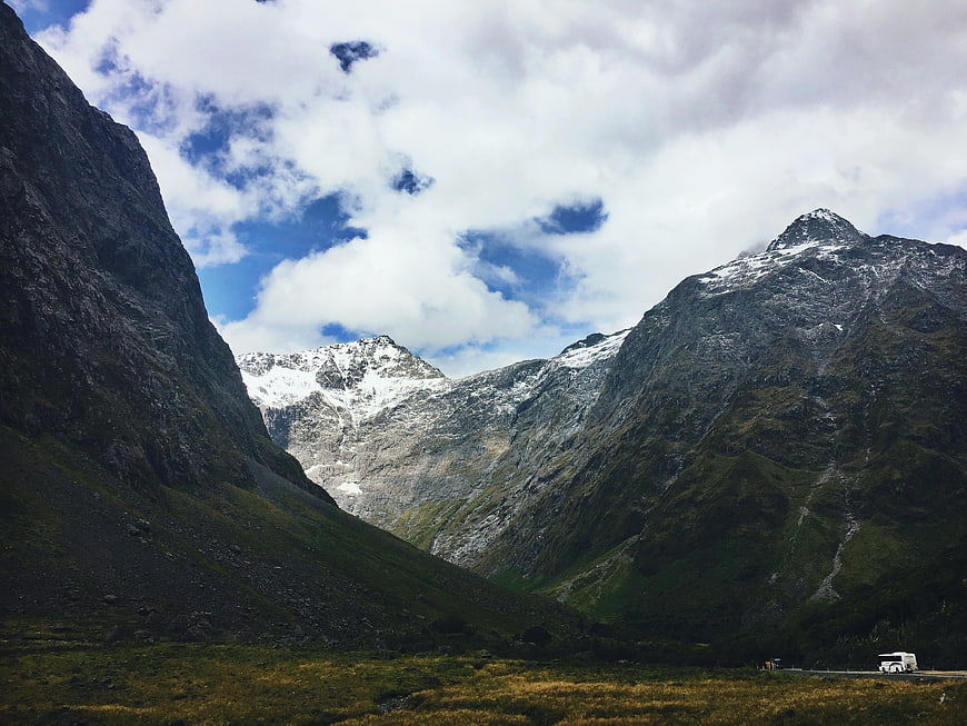 Majestic Snow-Capped Mountain Valley with Bus on Road