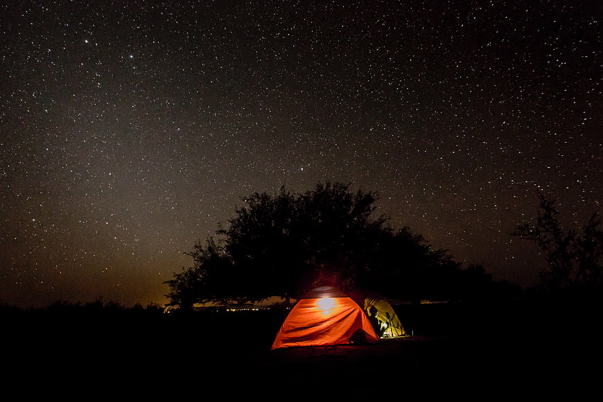 Glowing Camping Tent Under Starry Night Sky