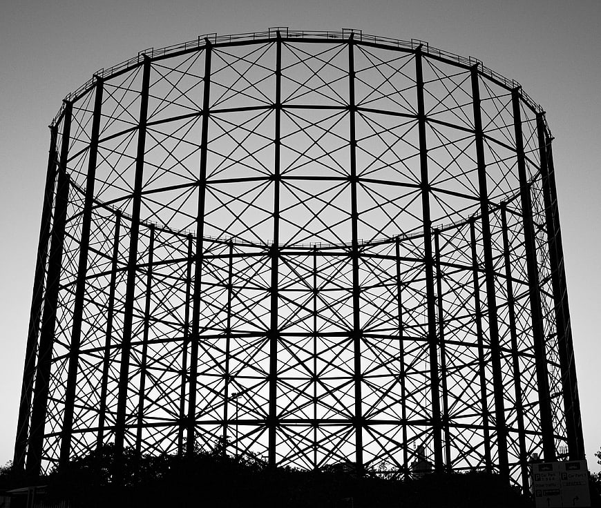 Black and white silhouette of a large gas holder structure