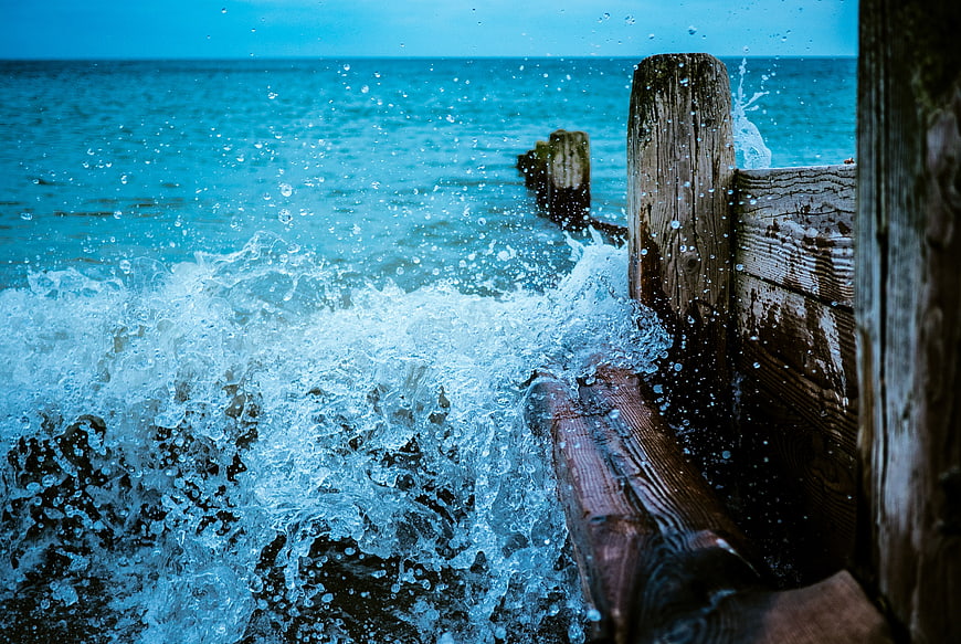 Ocean Waves Crashing Against Wooden Dock Pilings