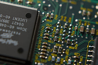 Close-up of green circuit board with microchip and electronic components