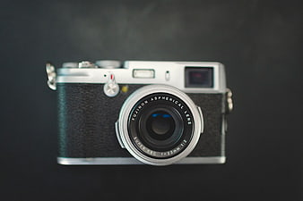 Silver and black Fujifilm X100V camera on dark background