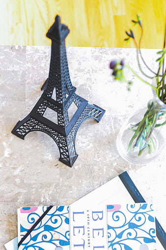 Black Eiffel Tower Model on Marble Desk with Book